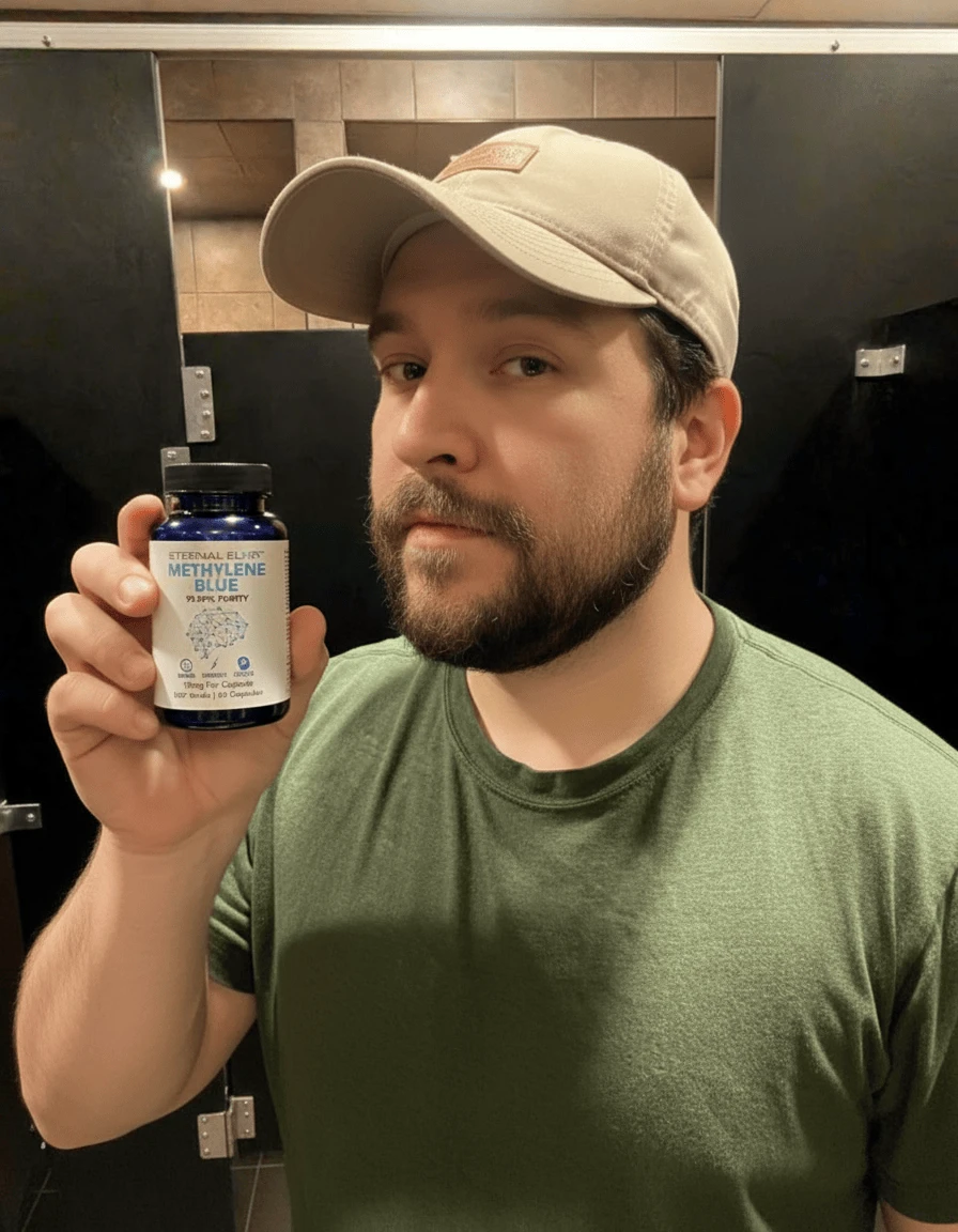 Man in a cap holding a bottle of Eternal Elixir Methylene Blue capsules