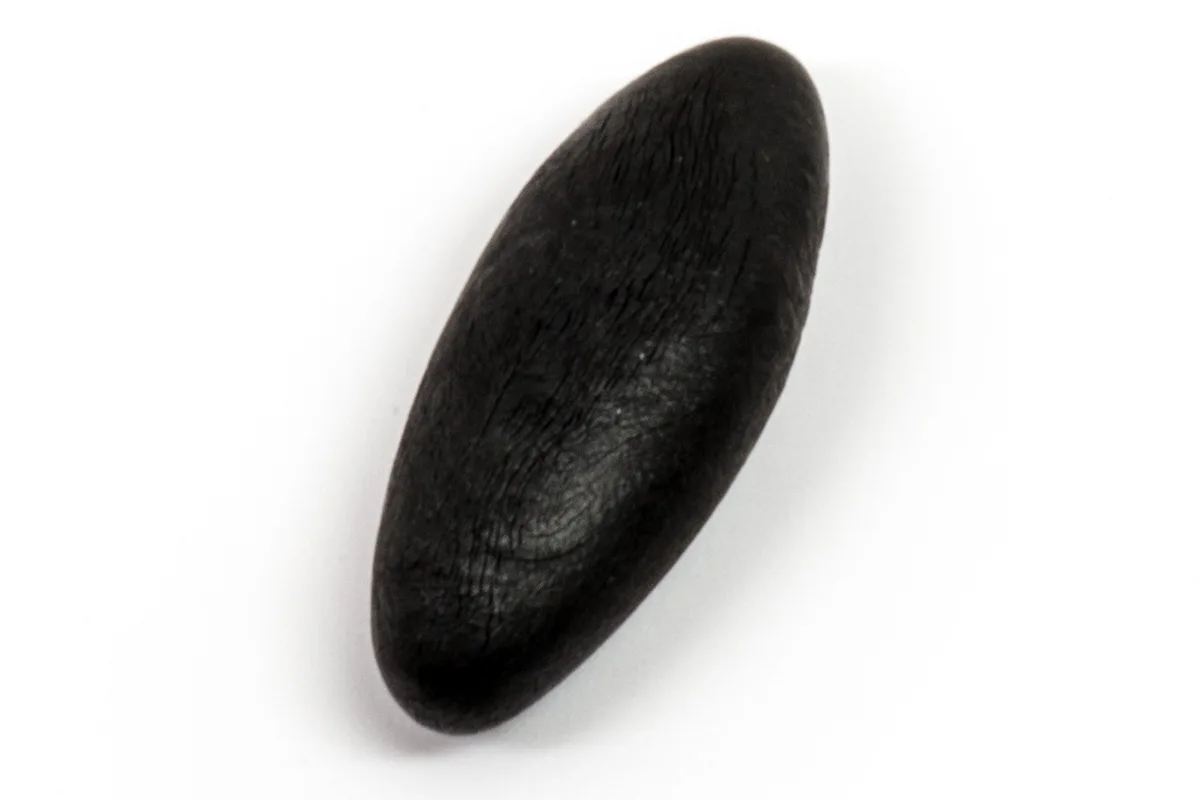 A piece of purified black shilajit resin on a pale background