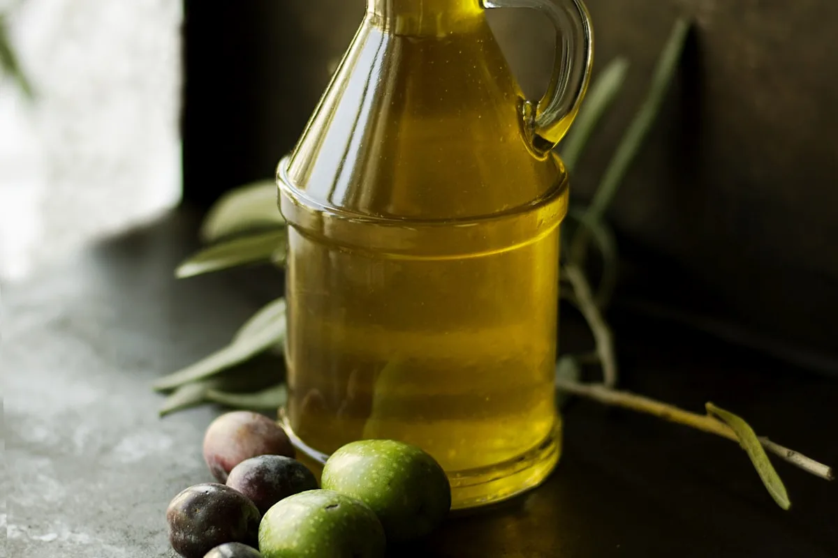 Golden oil beside coconuts in soft natural light