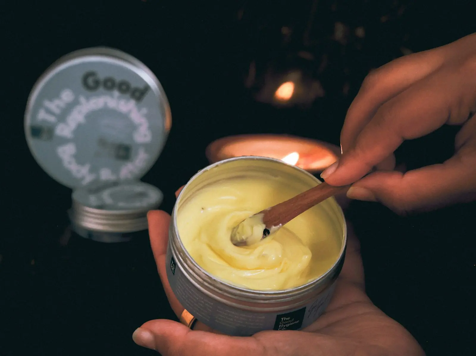 Hands holding a jar of rich skin balm